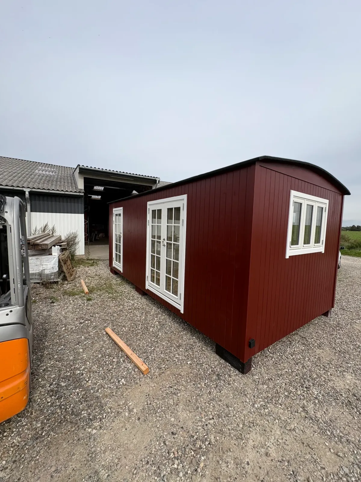 Facade med rød træbeklædning og hvide vinduer