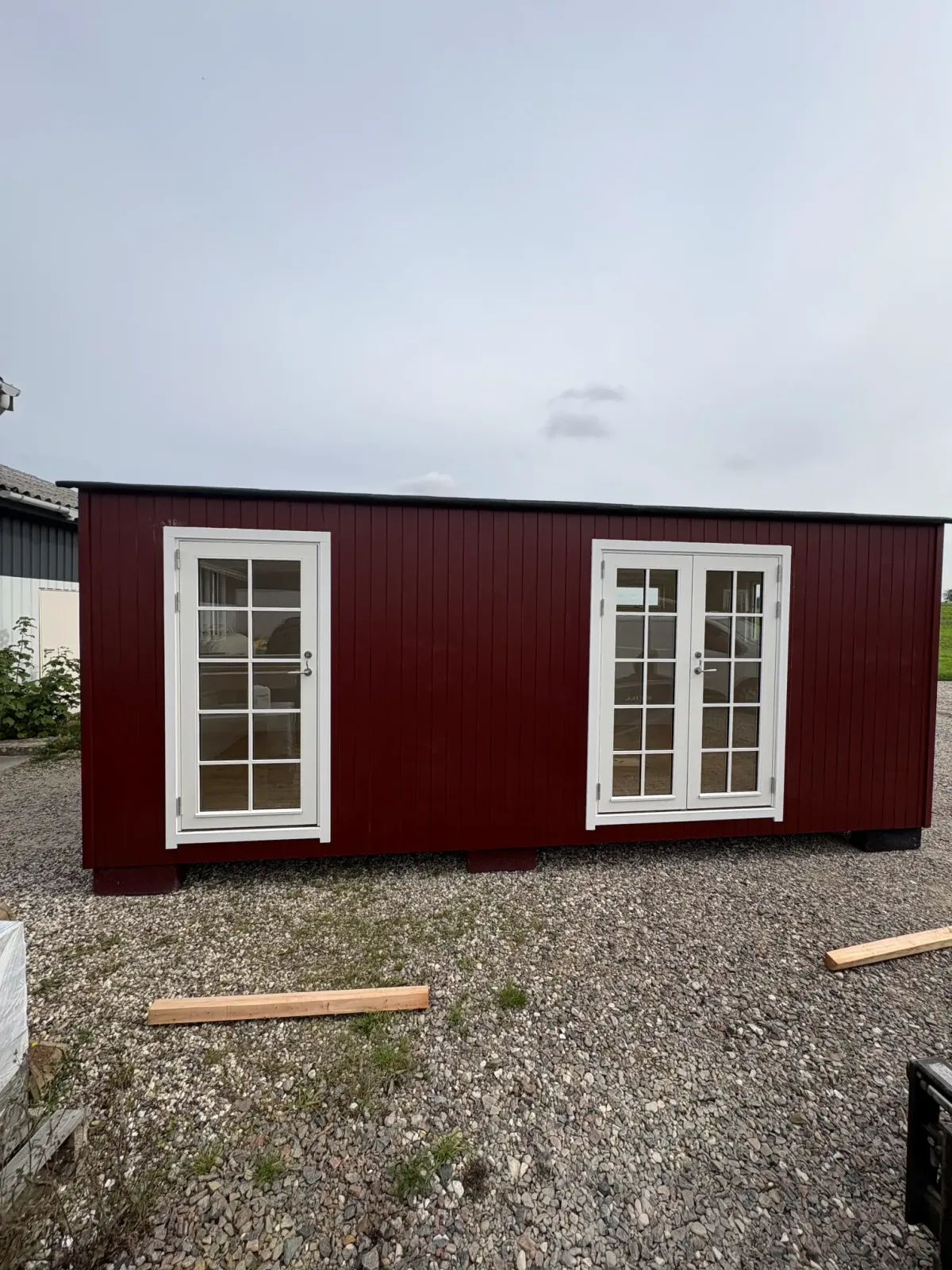 Rød træbeklædning med hvide vinduer og døre
